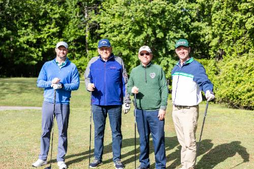 Four golfers posing with clubs