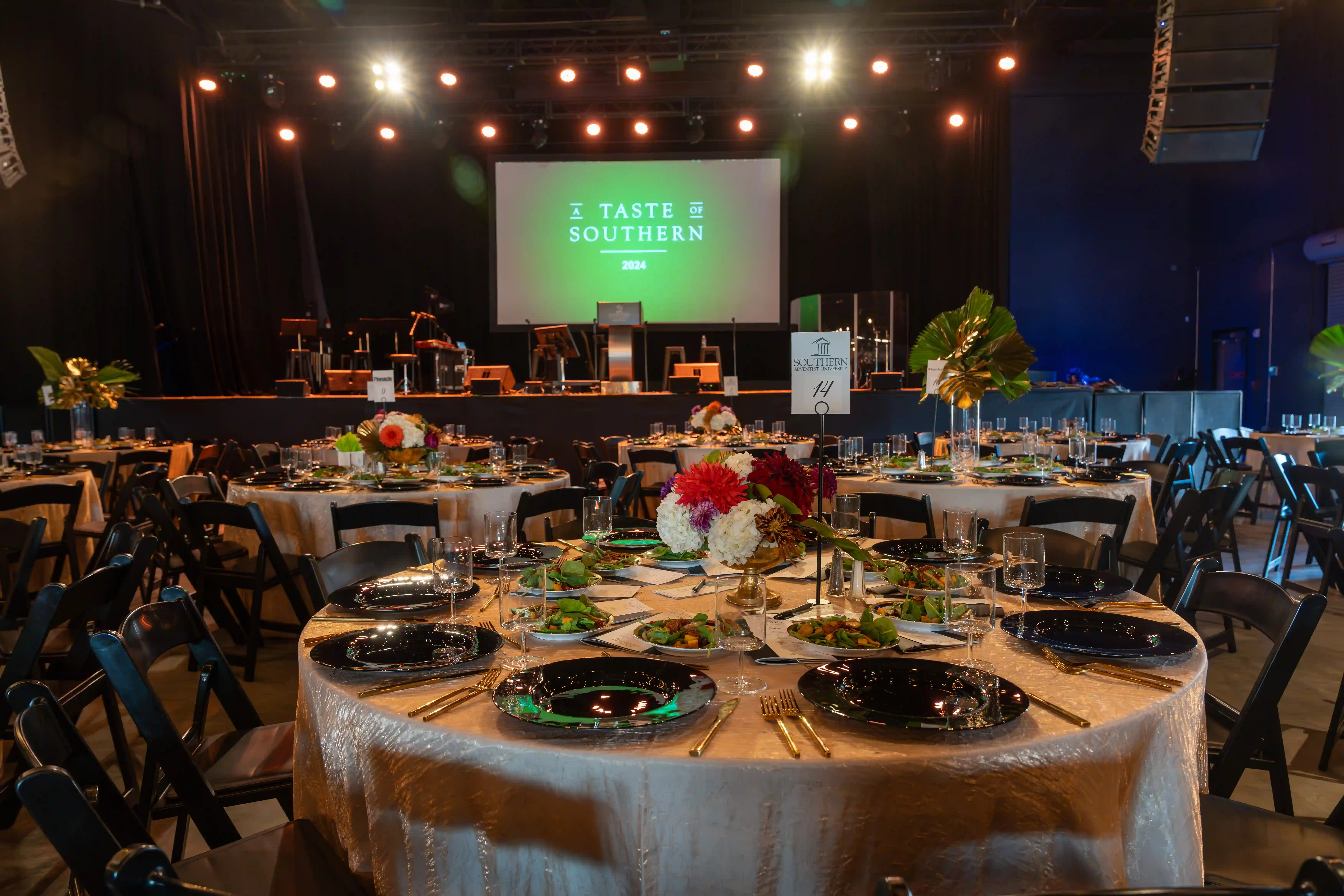 Wide shot of the event space focusing on a round dinner table on the foreground.