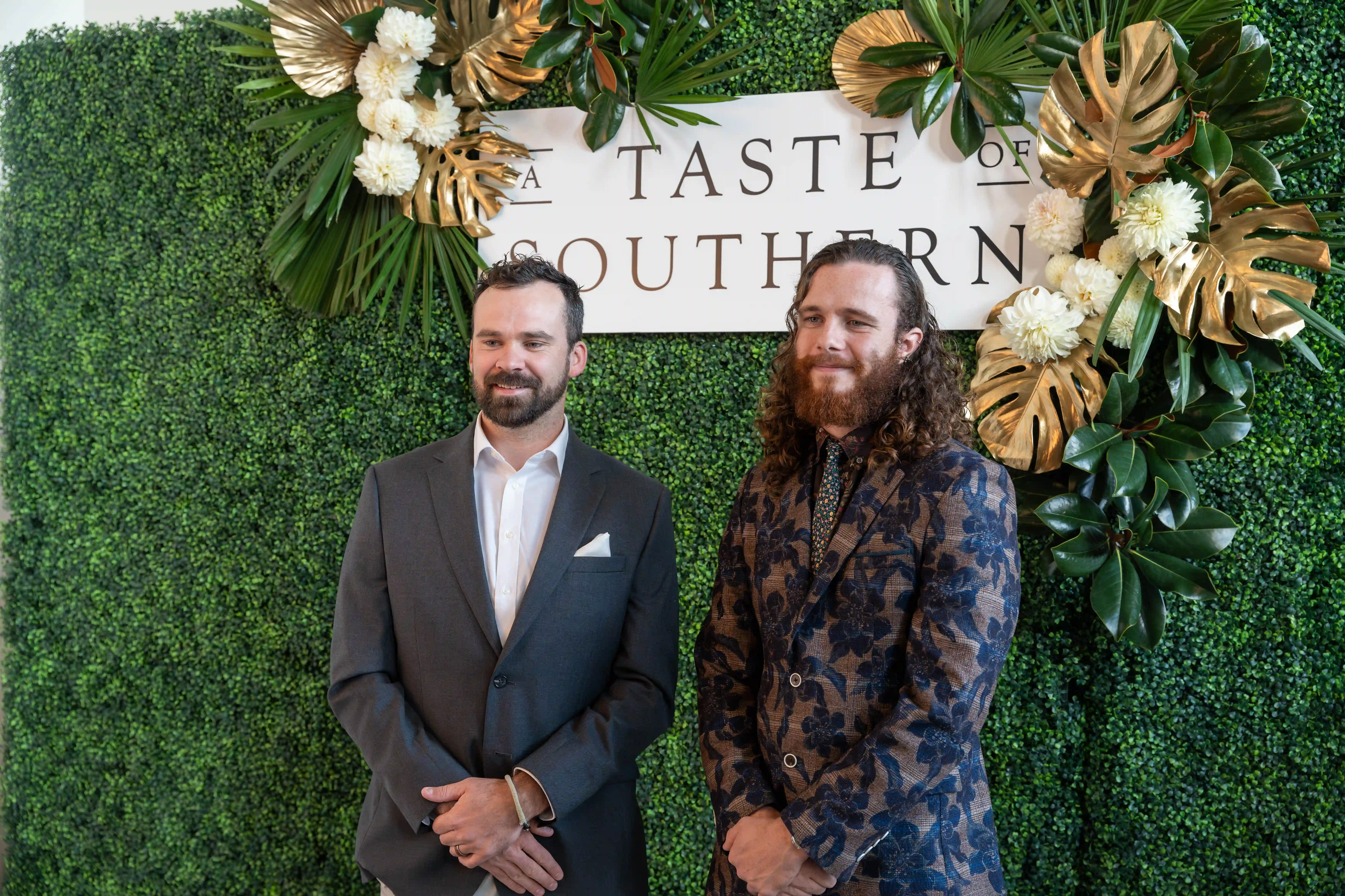 Travis Pyke and Max Haworth standing next to each other in front of a green backdrop