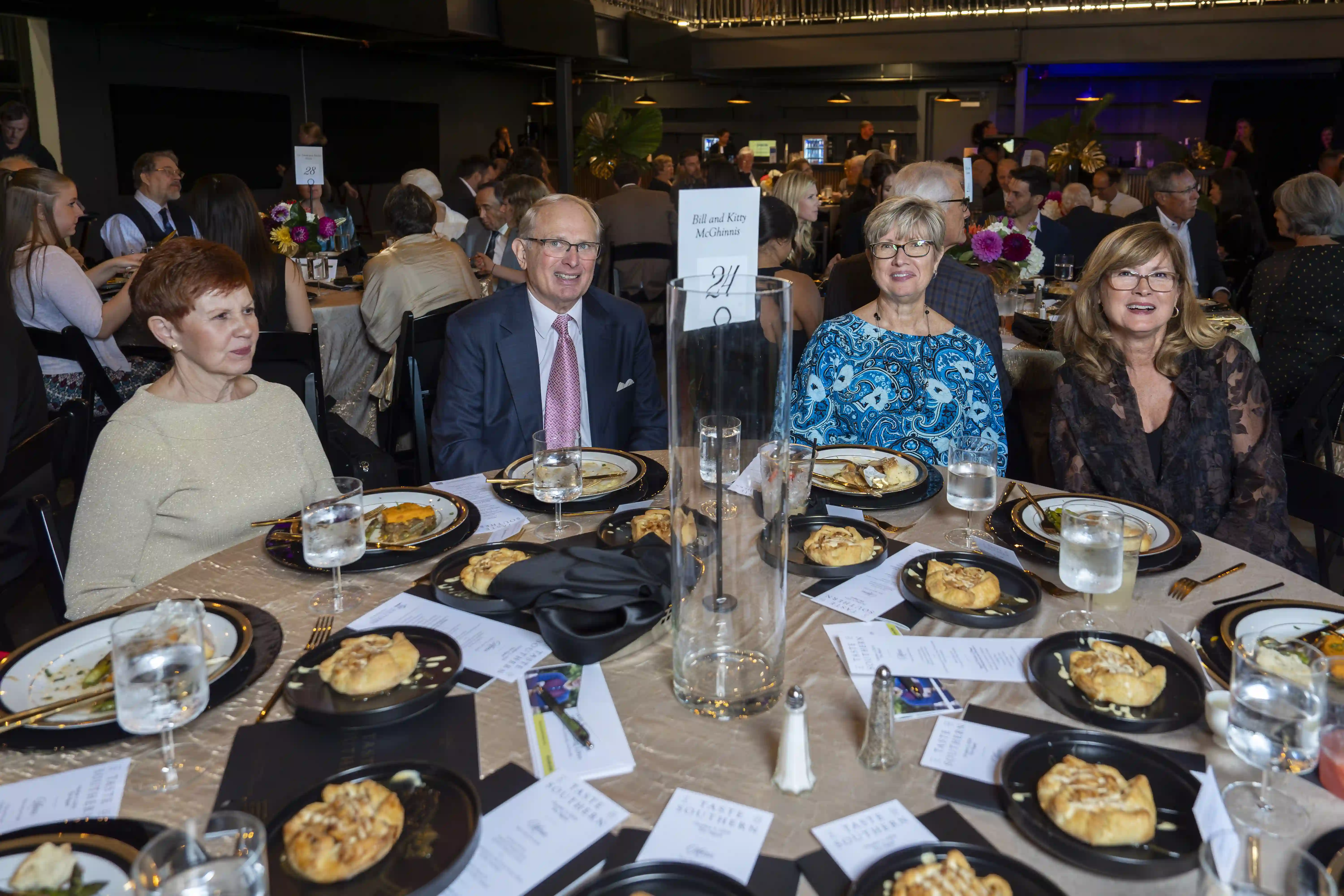 Bill and Kitty McGhinnis, Karla Ryan sitting at a table, posing for the photo