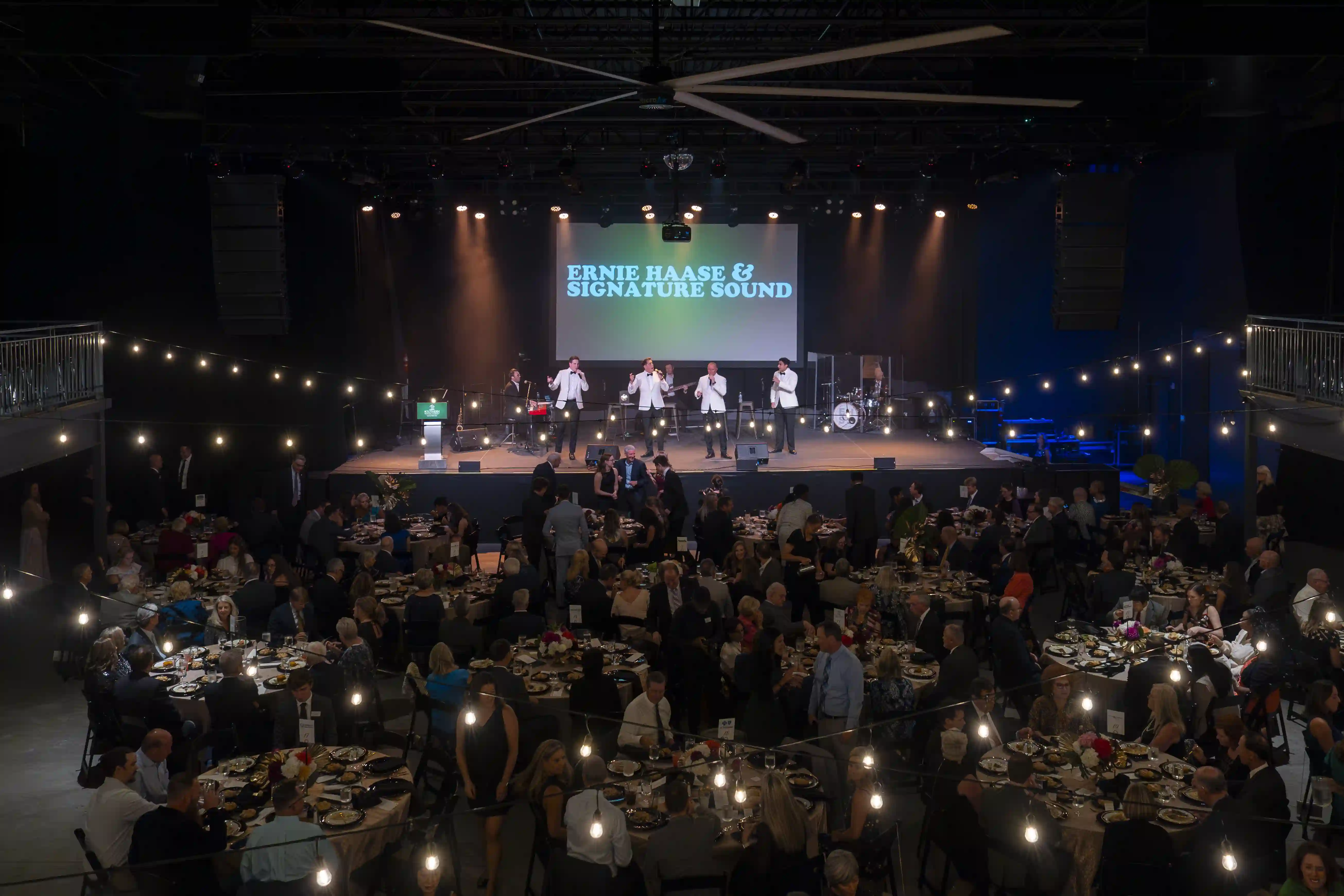 Ernie Haase and Signature Sound performing on stage as the guests watch from their tables