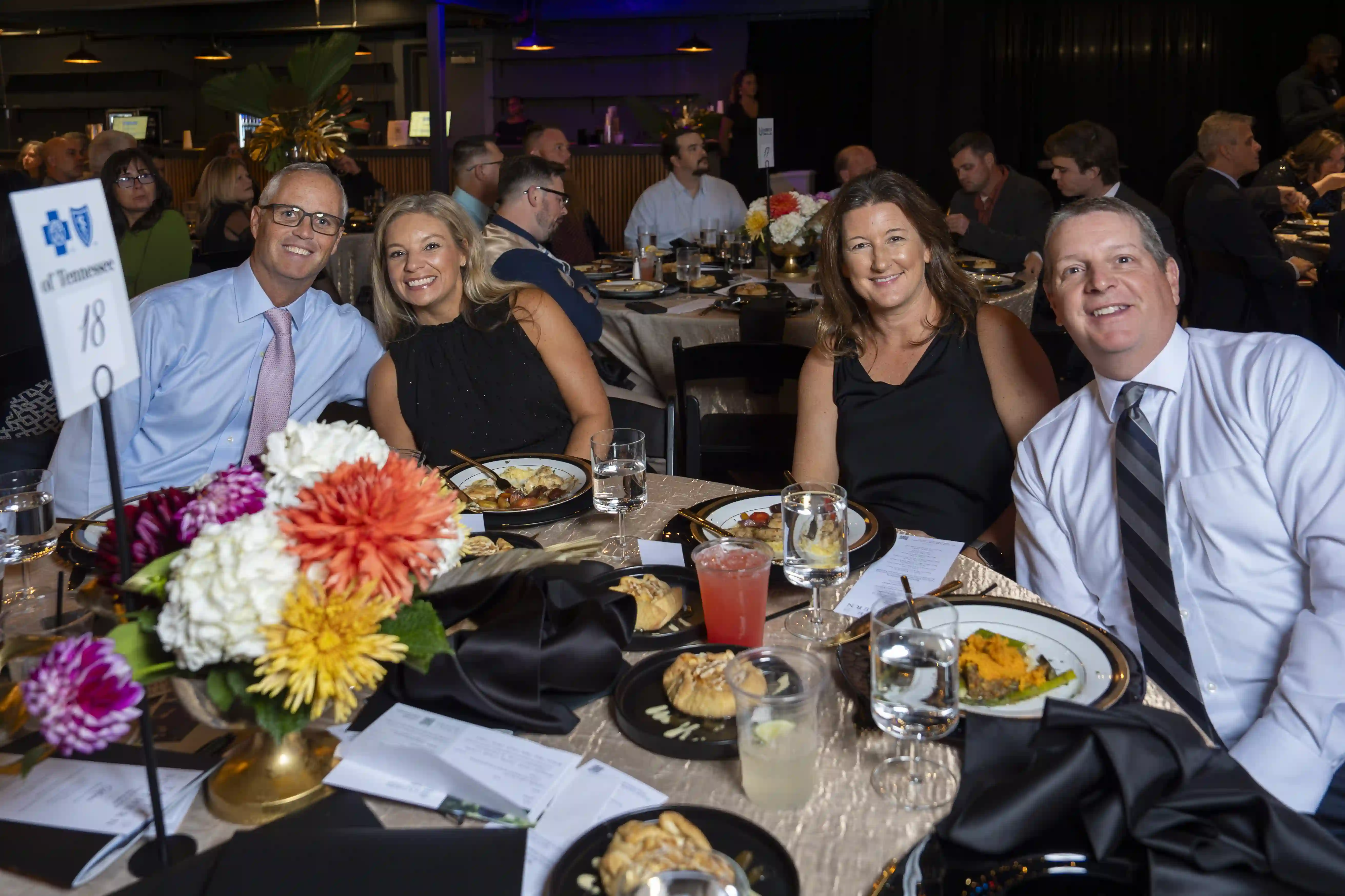 Jeff Guild, Jessica Guild, Jenny Sue Hocking, Jeff Hocking sit at a round table posing for the picture during the dinner portion of the evening. 