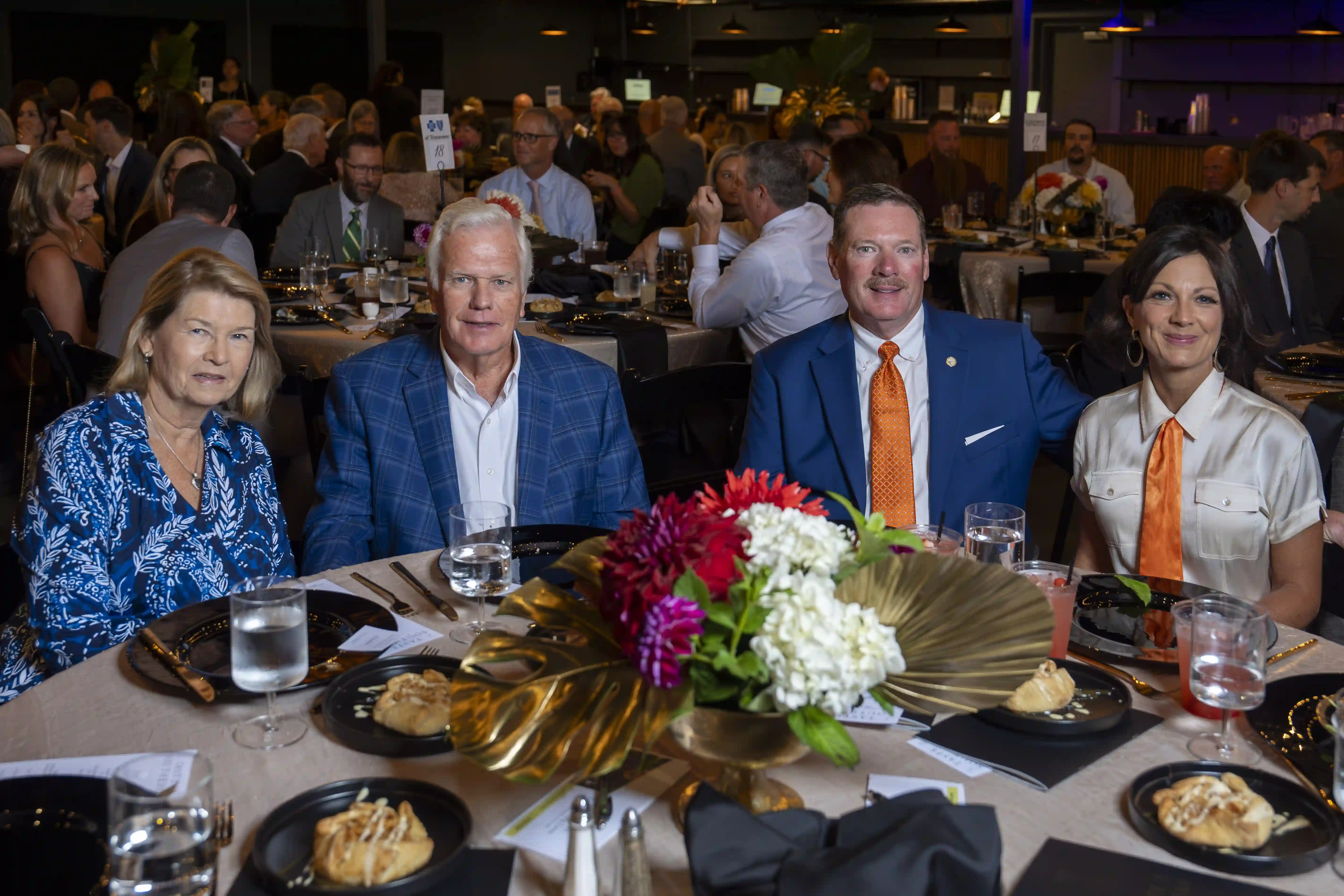 Linda Hullander, Bill Hullander, Jeff Eversole, Denise Eversole sit at a round table posing for the picture during the dinner portion of the evening.