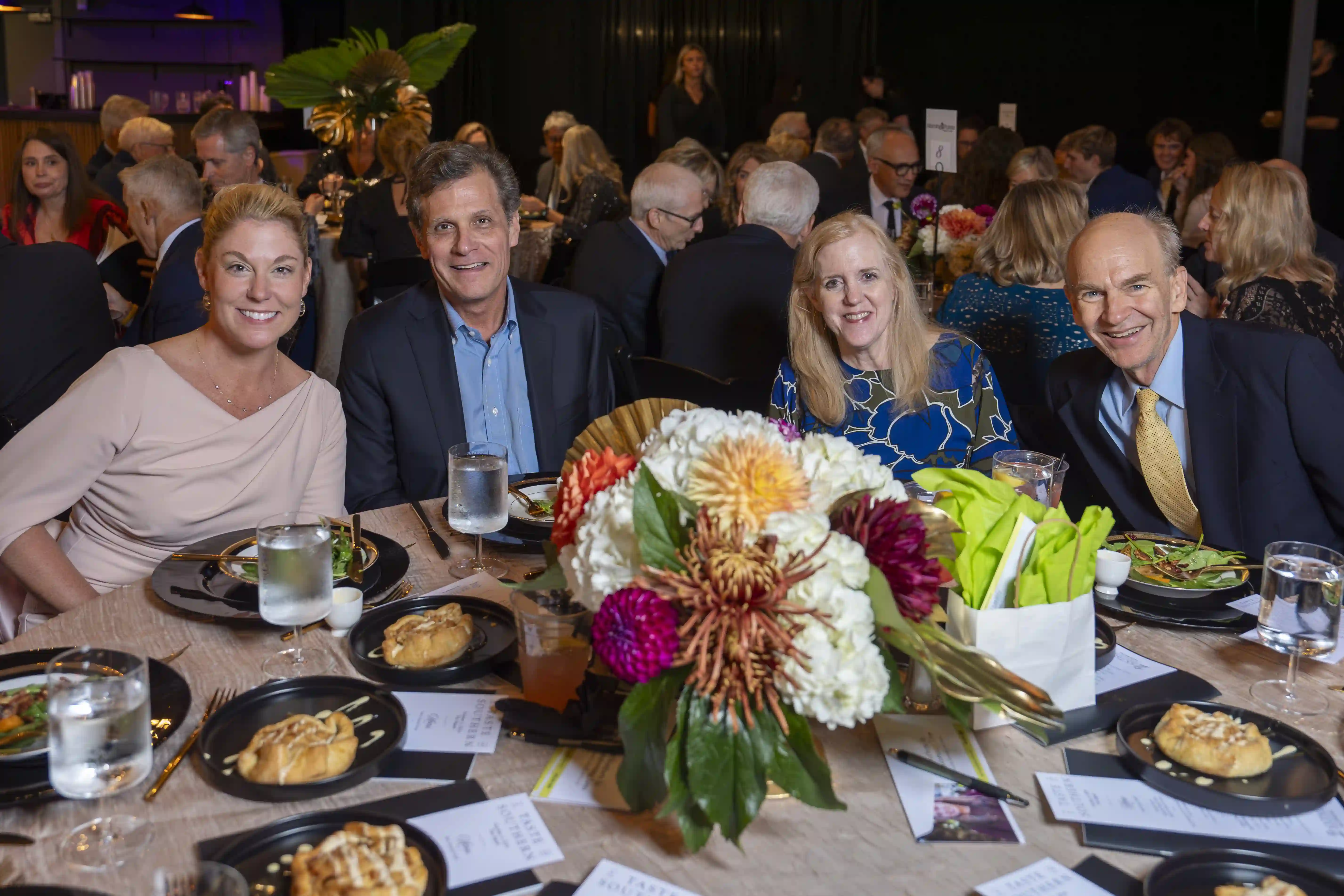 Lynn Brown, Danny Gork, Elizabeth Qualey, Roger Qualey sit around a table posing for the picture during the dinner portion of the evening.