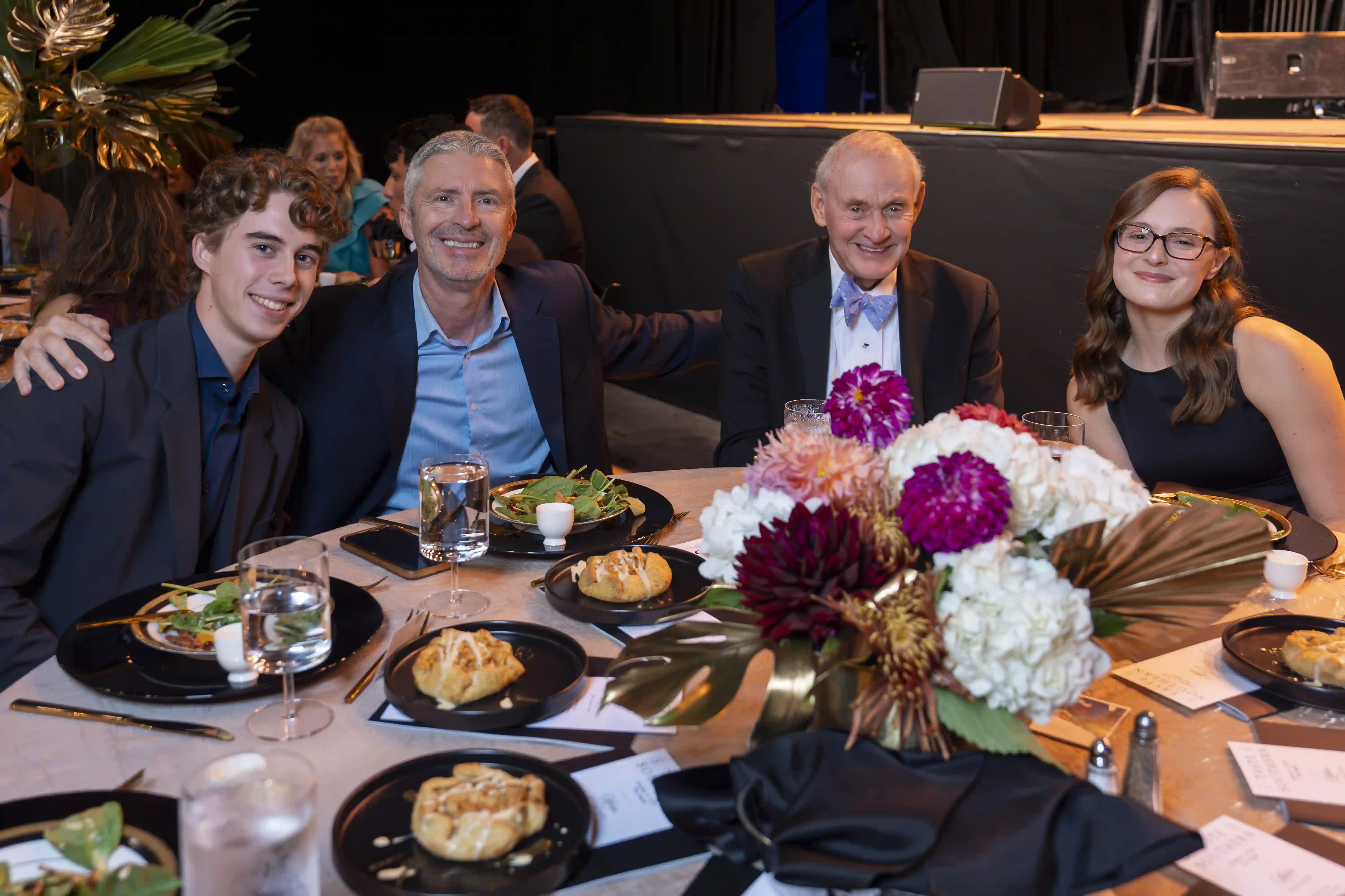 Four guests seated at a table posing for the camera