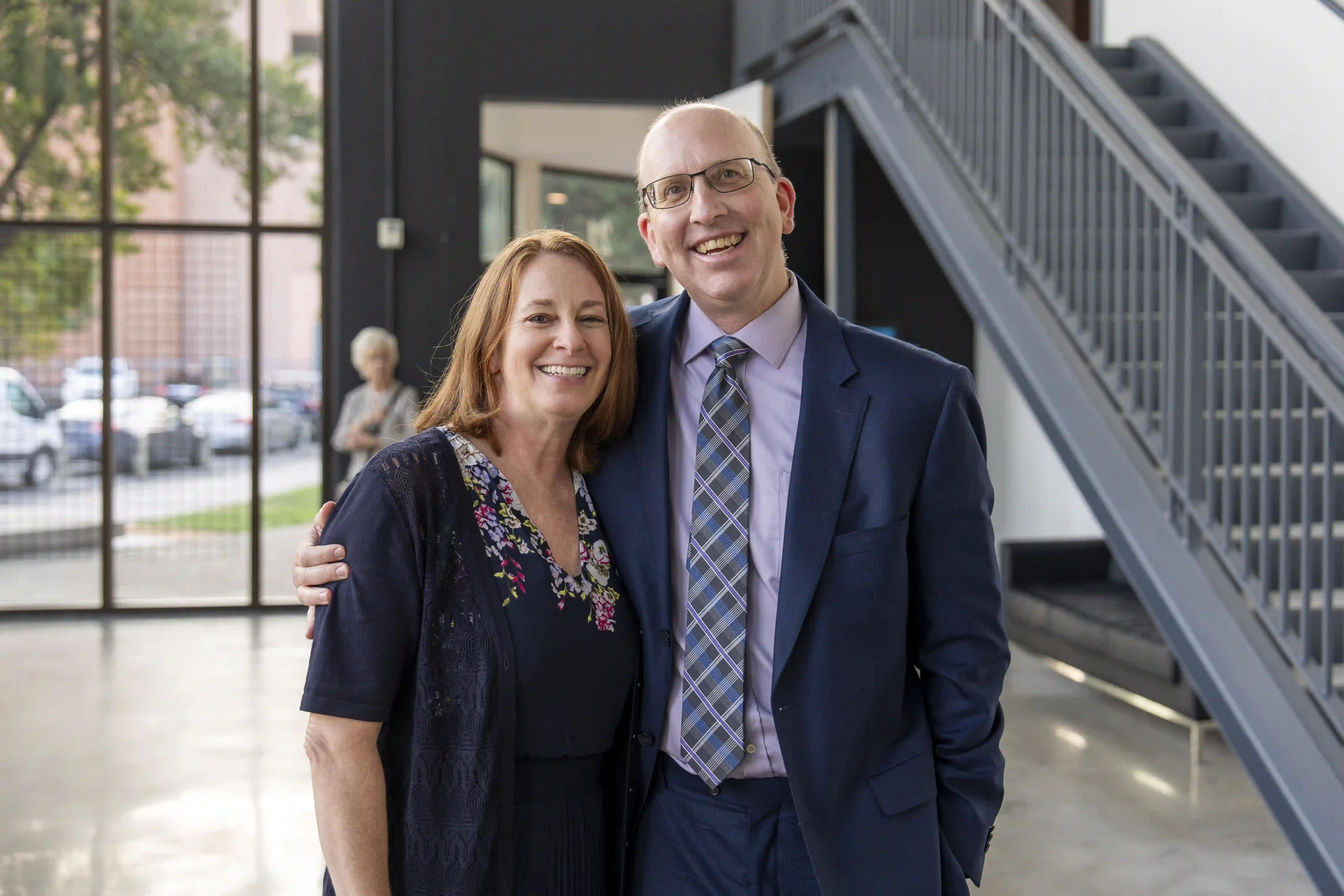 Wendi and Chris Barber standing together in a side-by-side embrace for the camera