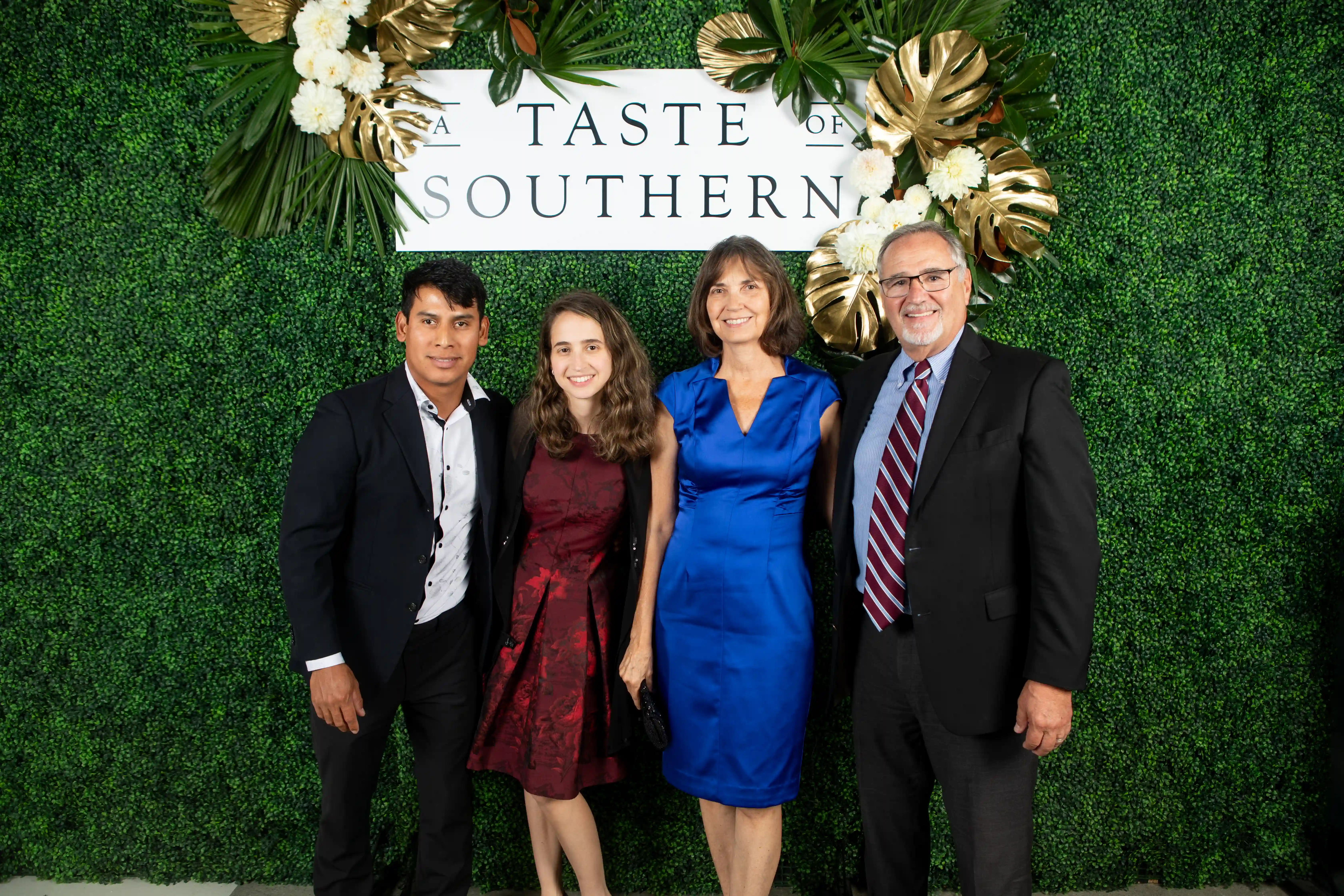 Jose, Christina, Carolyn, and David Jimenez standing together in front of a green backdrop