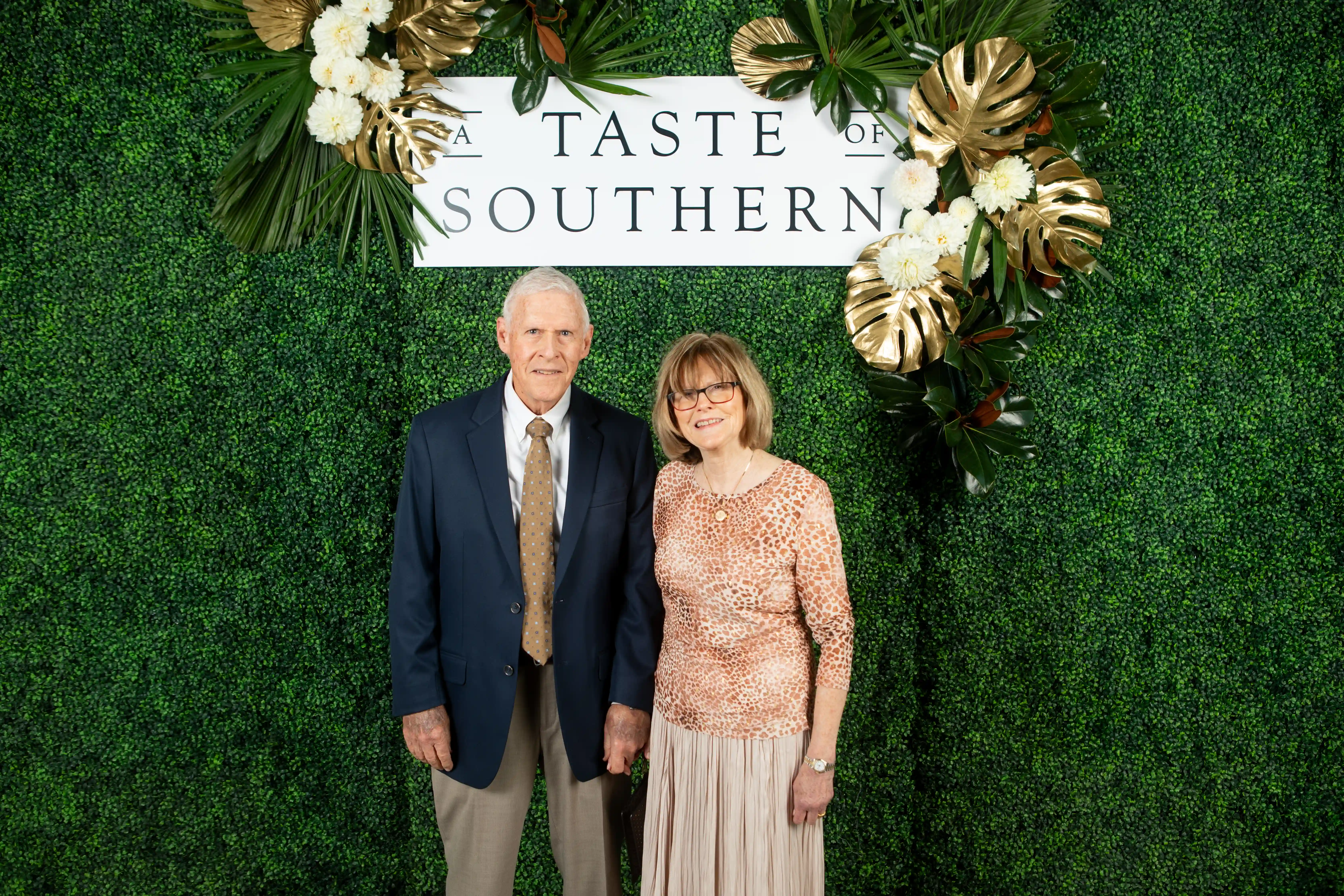 Art and Joyce Richert standing side-by-side in front of a green backdrop