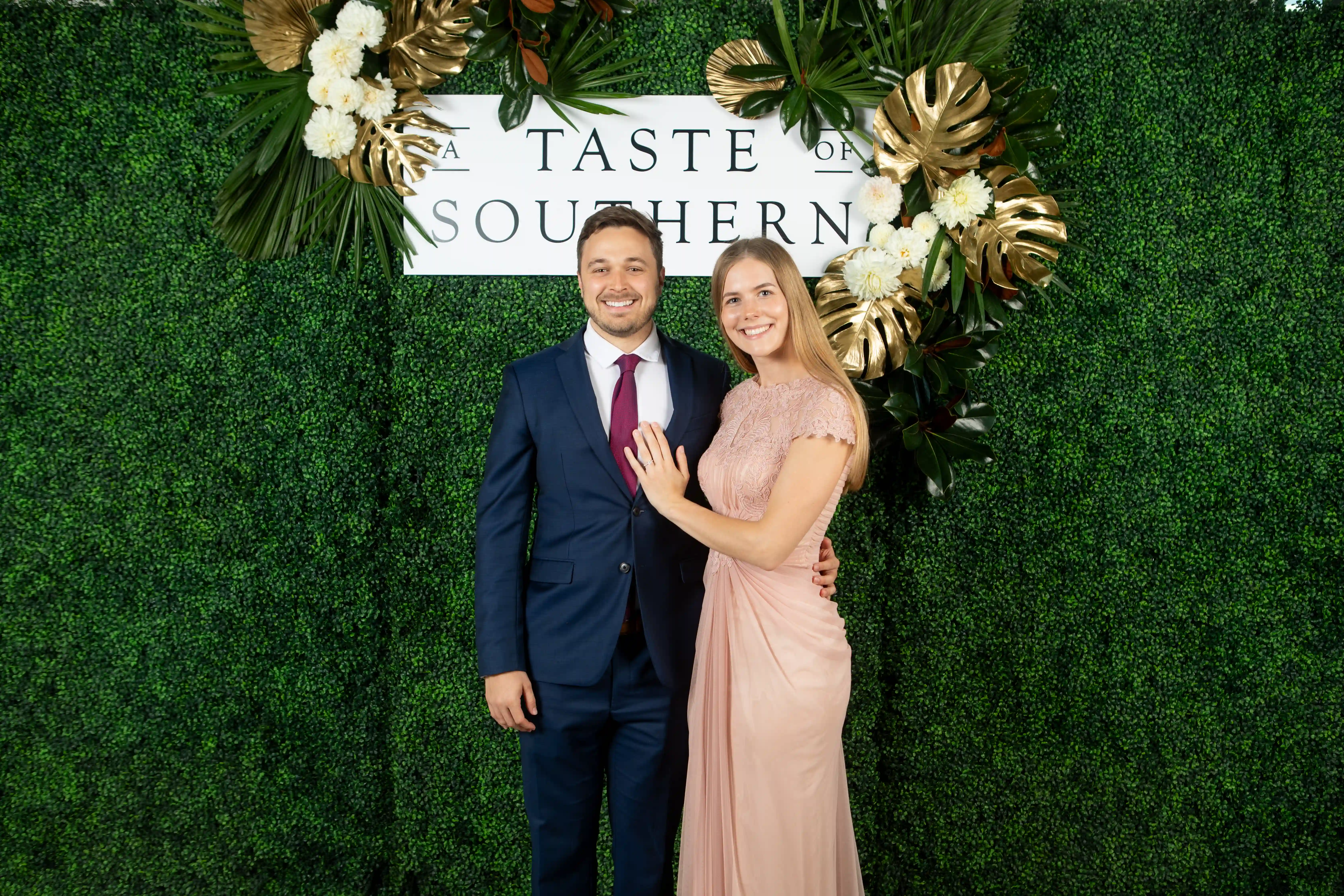 Noah Johnson and Joy Burdick stand side-by-side in front of a green backdrop