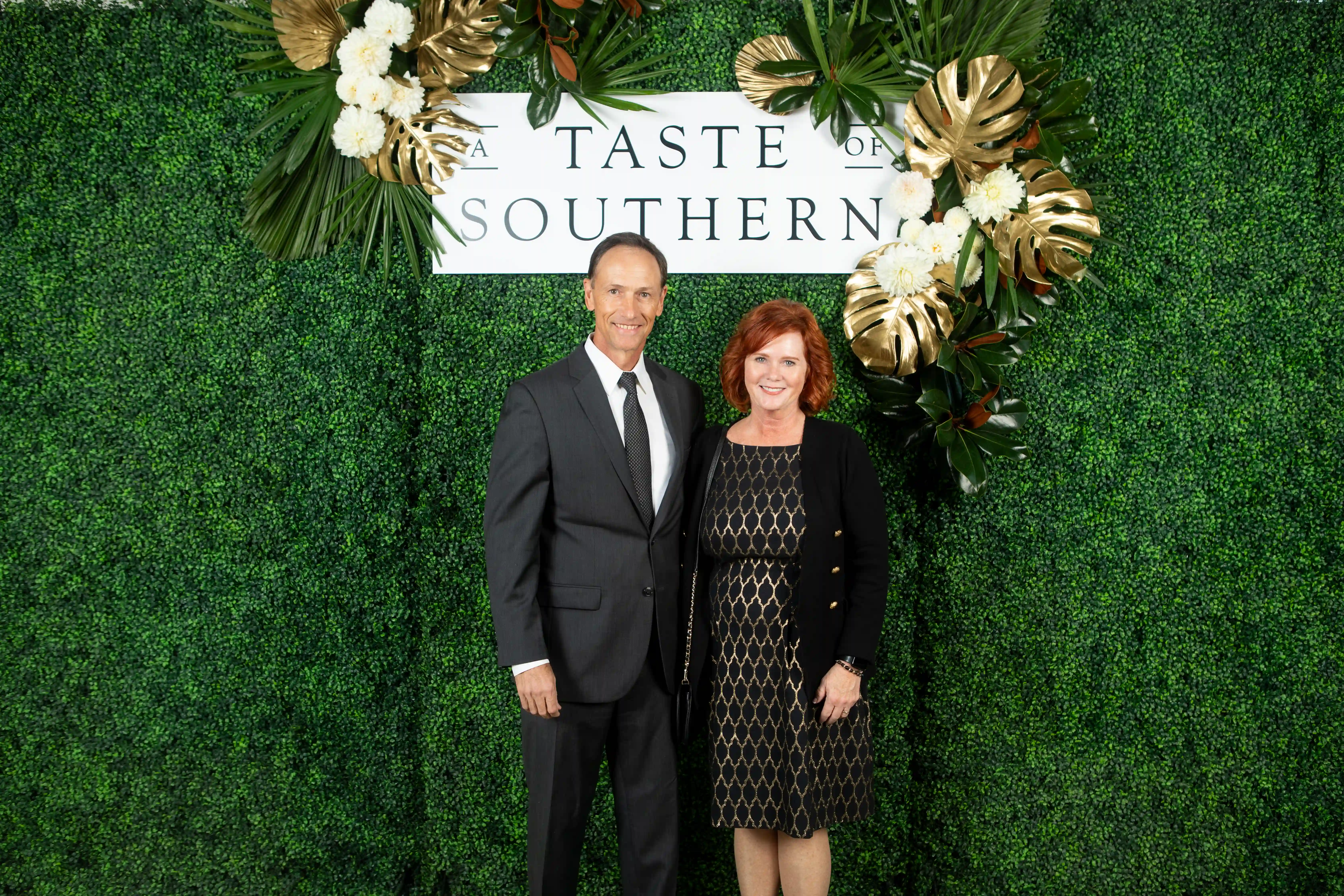 David and Ronda Huisman standing side-by-side in front of a green backdrop