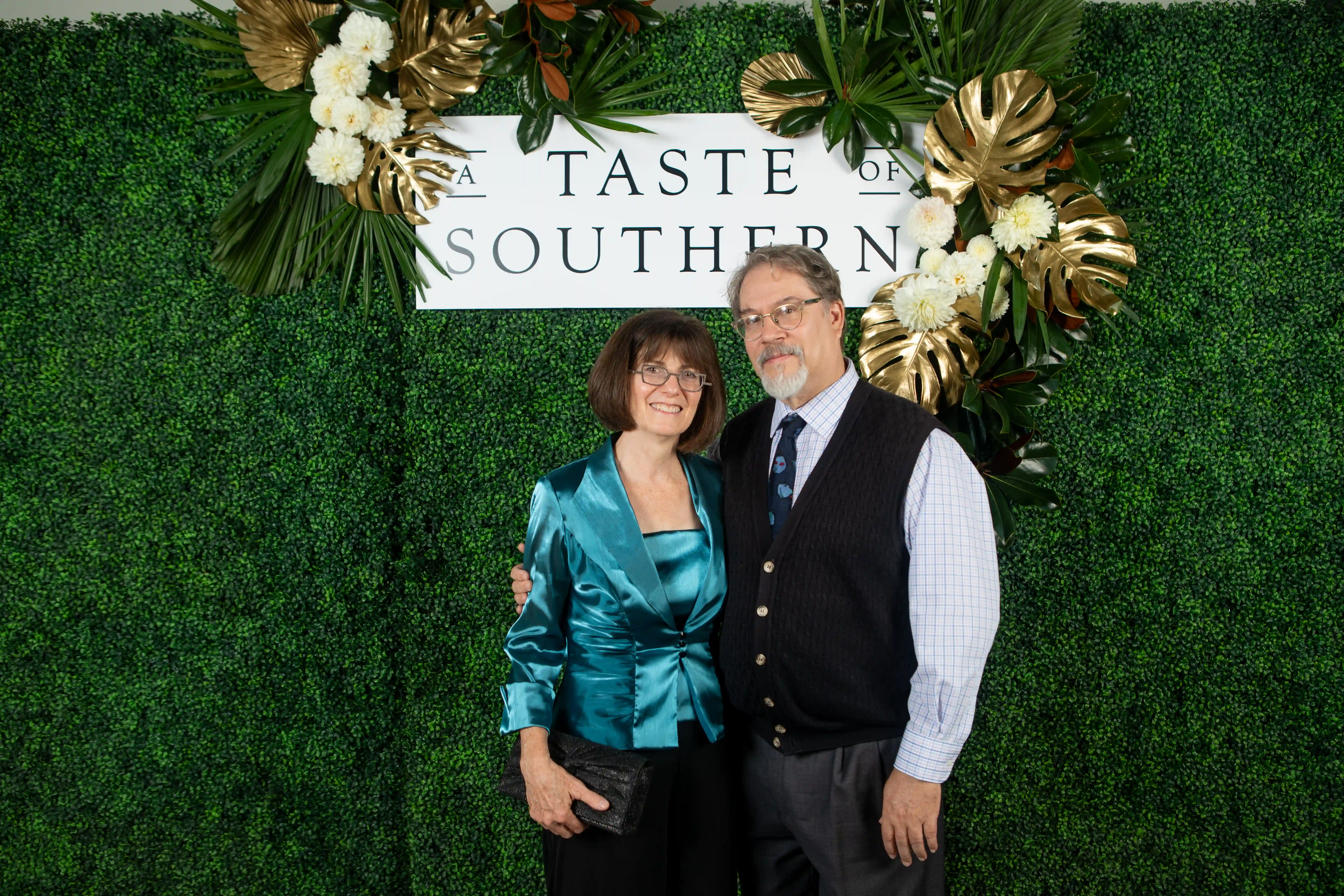 Sondra and David Shields embracing side-by-side in front of a green backdrop