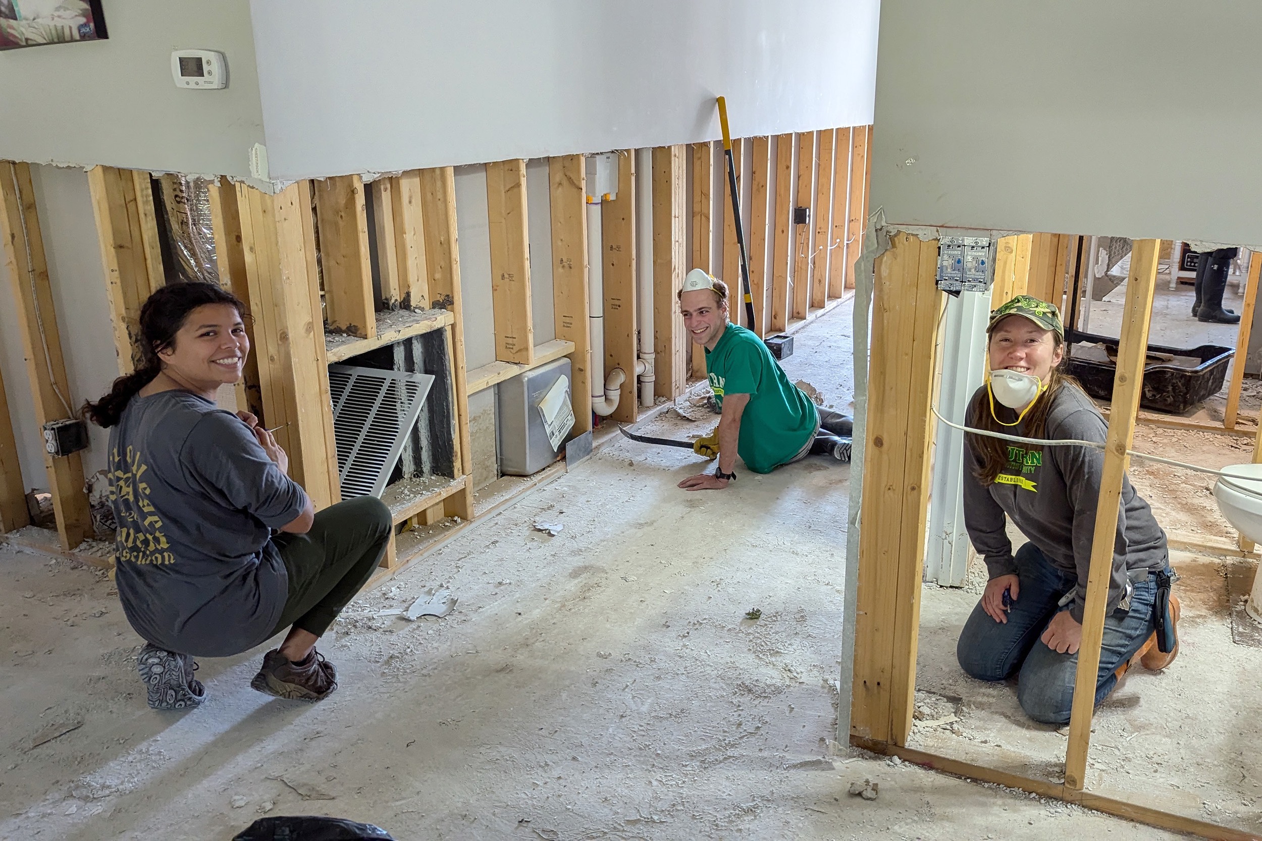 Three volunteers assist with Hurricane Helene clean-up efforts in a North Carolina home.