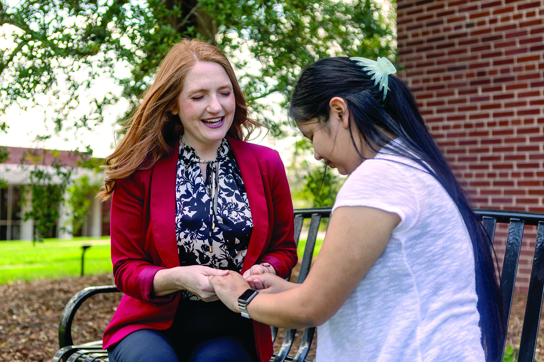 a faculty member prays with a student